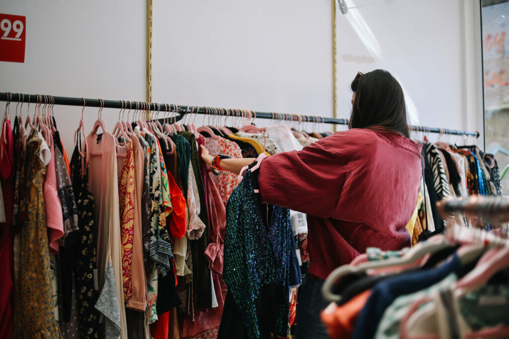 vrouw zoekt kleding uit bij de kledingbank